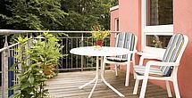 Auf dem Balkon des betreuten Wohnens im Pflegeheim Bremen genießt man Kaffee und Kuchen.