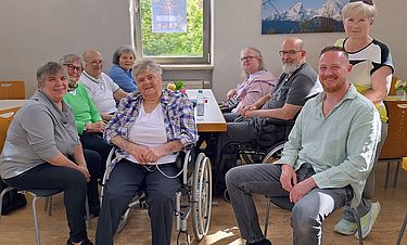 Die Bewohnenden mit Begleitern beim Kaffeetrinken im katholischen Gemeinde-
haus.