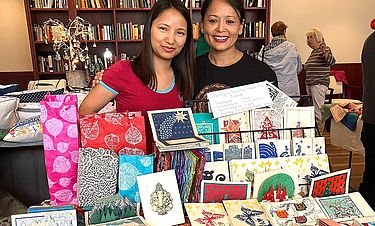 Zusammen mit der nepalesischen Auszubildenden Nishang Lama Tamang (l.) präsentiert Sulochana Gosai zum Weihnachtsfest geschmackvolle Papierwaren aus fairem Handel, die nachhaltig aus der Rinde einer Himalaya-Pflanze hergestellt werden.